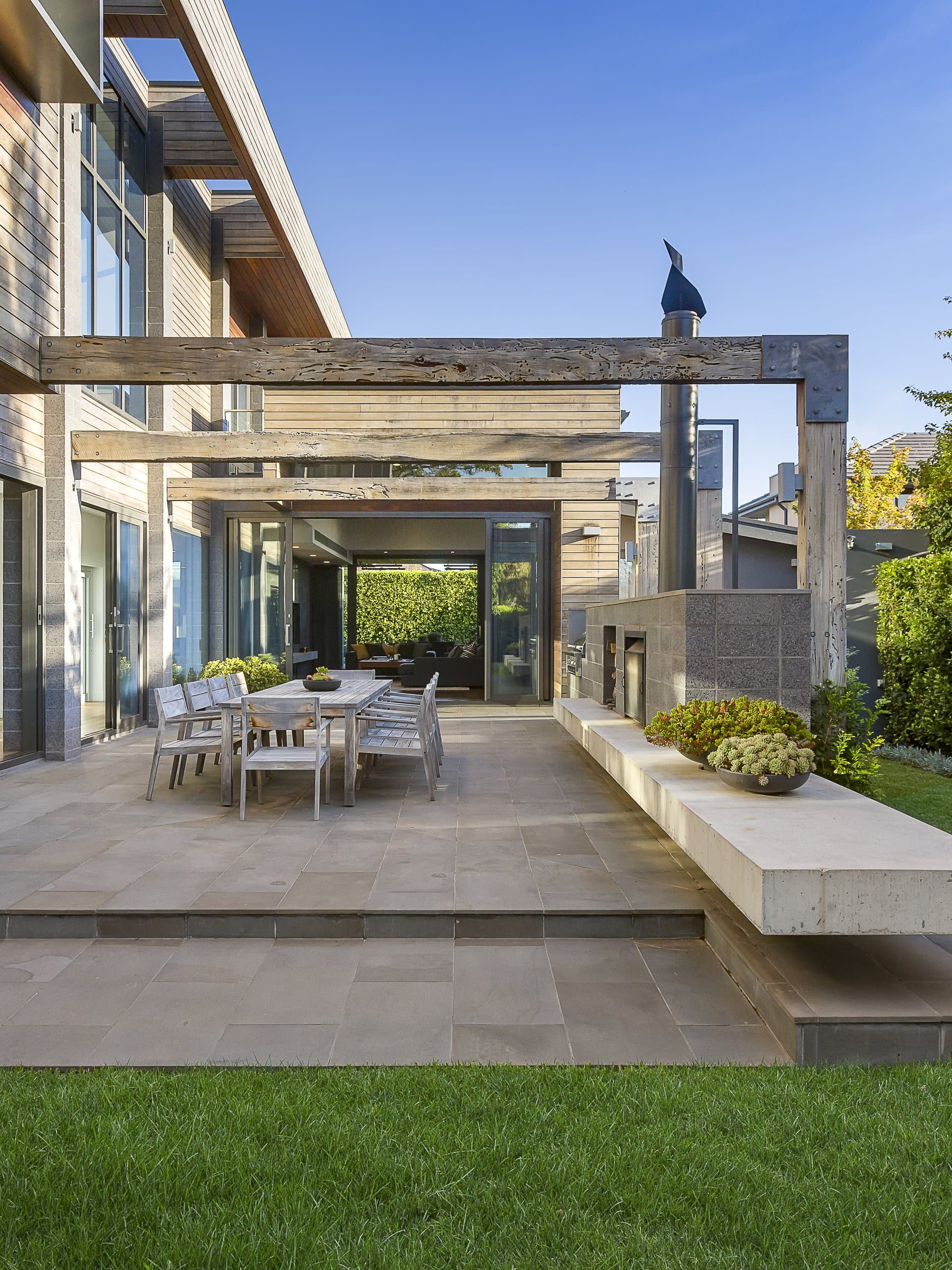 Garden lawn with pergola, stone bench, and clipped hedges