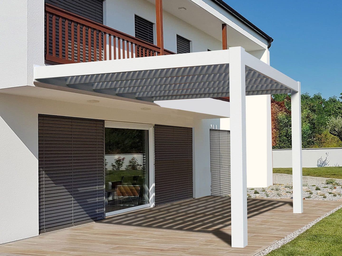 White wall-mounted aluminum pergola over a ground-level patio